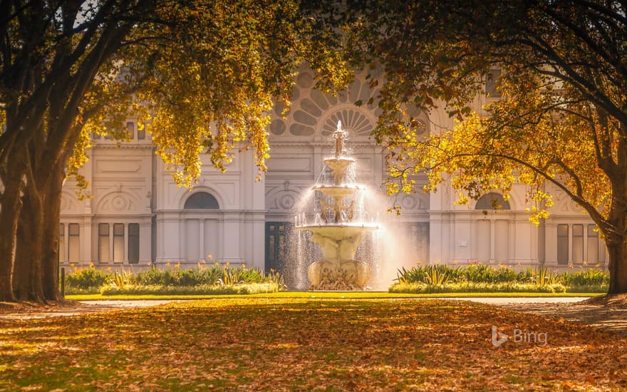 Carlton Gardens fountain and autumn trees catching the sunlight in front of the Royal Exhibition Building, Melbourne